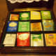 Ours has 12 squares or slots for teas and holds about 80 bags. Leave the lid open at celebrations so you can stand the bags for easier access.