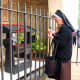 A Franciscan nun lighting a vigil candle at the shrine near the entrance of San Damiano.