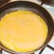 Beaten duck eggs added to omelette pan