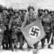 101st Airborne troops posing with a captured Nazi vehicle air identification sign two days after landing in Normandy June 8,1944.