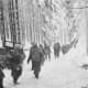 American troops walking along a path in the snow December 1944 in the Ardennes.