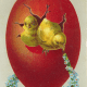 Two yellow Easter chicks coming out of a red Easter egg