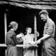 Sergeant Alvin C. York's mother is pouring water into the basin while his younger sister looks on. York turned down many lucrative offers, including one worth $30,000 to appear in vaudeville, to return to the life he had known before the war.