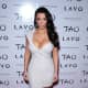 Kim Kardashian is curvy in a short and low cut dress and high heels