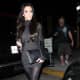 Kim Kardashian in a tight dress, stockings and high heels