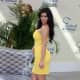 Kim Kardashian wearing a pretty yellow dress and high heels