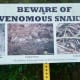 Signs posted warning of snakes  in Bud Hadfield Park.