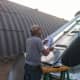 A crew member studies the lid components and decides a course of action.