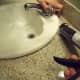 Use a caulking gun to apply silicone caulk around the sink.