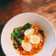 Curry noodles with hard-boiled eggs, mustard green, and shrimp. The broth is made from coconut milk and curry powder.