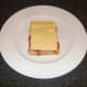 Cheese is placed on the sandwich which is now ready for grilling/broiling