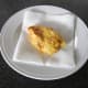 Deep fried chicken is drained on kitchen paper and rested