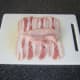 Chicken breast fillet is laid on pancetta and sliced open along the centre