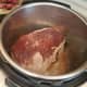 Flip after 5 minutes or so, and one side is browned. Then add in half of your beef broth and scrape the bottom of the pot with a plastic spatula.