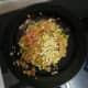 Add green chillies and chopped onions. Stir for a minute, then add chopped ginger and garlic.
