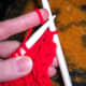Draw the yarn through the needles when you need to switch back to the knit stitch and let it hang down the back of the project.