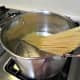 Putting the linguine into the boiling salted water to cook