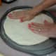 Gently stretch the dough by pressing down with floured fingers.