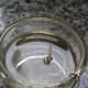 Hook the other end of the wire over the lip of the glass container. Arrange the wire so that it holds the wick about 1/4 inch above the oil.