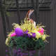 Holiday Hanging Basket Colorful Exterior Easter Decoration with yellow forsythia and pink flowers and a purple egg
