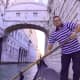 Gondolier in front of the Bridge of Sighs