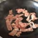 Frying sliced bacon.