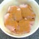 Curry powder and seasoning are scattered over chicken thighs.