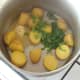 Butter and coriander are added to drained potatoes