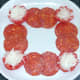 Chorizo slices are arranged around plate border