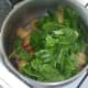Baby spinach leaves are laid on top of hot potatoes