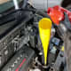 Pouring in a fresh batch of transmission fluid to complete the process.