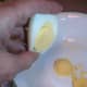 Bend the eggs slightly to pop out the yolk into a mixing bowl.