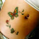 A butterfly tattoo is seen on this person's stomach.
