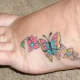 This person has placed a butterfly tattoo on their foot.