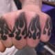 Flame tattoos on the knuckles.