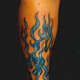 This colorful tattoo features blue flames.