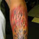 An intricate and colorful flaming skull tattoo.