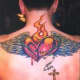 A winged flaming heart tattoo with a cross.
