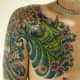 Another green hannya tattoo with flowers and waves.