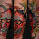 A vibrant red hannya mask tattoo.