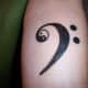 Een F-clef tatoeage met een yin yang erin.