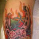 A horseshoe, dice, flames, stars, and a spade are depicted in this tattoo.