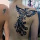 A coverup tattoo on a small pattern with a tribal phoenix.
