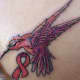 Pink ribbon and bird tattoo.