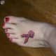 Pink ribbon tattoo on foot.