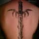 A sword tattoo with almost organic elements, like thorns and claws.