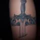 In this tattoo, the sword appears to be piercing the wearer's flesh.