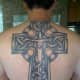 A tattoo of a sword and a cross.