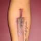 A unique sword tattoo featuring a large blade.