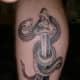 In this tattoo, a snake wraps around the sword.